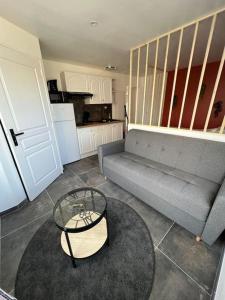 un salon avec un canapé et une table dans l'établissement Studio Berck , proche plage , phare , centre ville, à Berck-sur-Mer