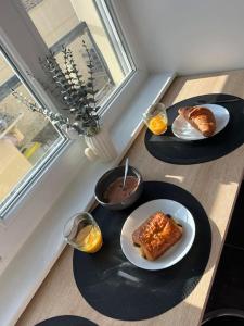 une table avec deux assiettes de nourriture et des verres de vin dans l'établissement Studio Berck , proche plage , phare , centre ville, à Berck-sur-Mer