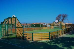 um campo de ténis com duas redes por cima em Chez Fifi au Barcarès em Le Barcarès