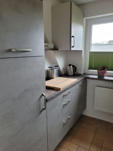 eine Küche mit Küchengeräten aus Edelstahl und einem Fenster in der Unterkunft Ferienwohnung Strandnah in Cuxhaven