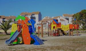 un parque infantil con un equipo de juegos colorido en la playa en Chez Fifi au Barcarès en Le Barcarès