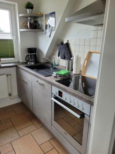 eine Küche mit Spüle und Herd Oberer Backofen in der Unterkunft Ferienwohnung Strandnah in Cuxhaven