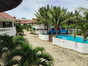 a resort with a swimming pool and palm trees at Barizieum Nest 1BR, Diani in Kwale