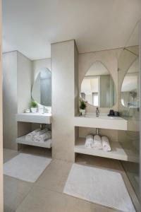 a bathroom with two sinks and two mirrors at Allenbeach TLV- apart Hotel- Adults only in Tel Aviv