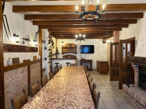 een lange tafel in een kamer met een open haard bij 5 bedrooms villa with city view private pool and enclosed garden at Bizkaia in Emaldia