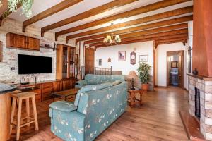 Casa Rural Tijoco Bajo Con Jacuzzi Adeje في أديخي: غرفة معيشة مع أريكة زرقاء وتلفزيون
