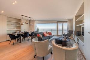 un salon avec un canapé et une table dans l'établissement 7e verdiep Appartement met zeezicht in Knokke voor max 6 personen, à Knokke-Heist