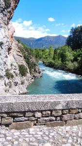 a river with a stone wall next to a river at Hostal Turbon in Campo