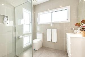 a bathroom with a toilet and a glass shower at 3 Pillars - Pet Friendly - 4 Mins Walk to Beach in Callala Beach +32 photos