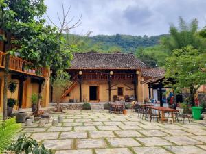 a building with a patio with tables and chairs at Mam Da Homstay in Na Hang