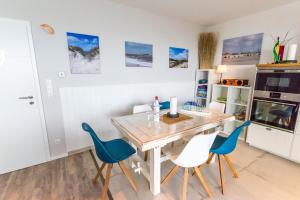 a kitchen with a wooden table and blue chairs at Haus Seaside-Dahme in Dahme