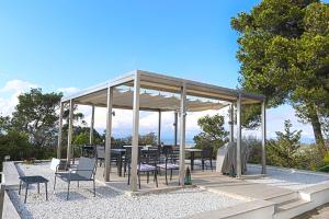 einen Pavillon mit Stühlen sowie einem Tisch und Stühlen in der Unterkunft Aya House in Barcelona