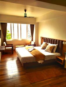 a bedroom with a large bed and a large window at The Bassu's Gangtok in Gangtok
