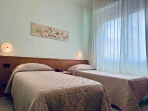 a room with two beds and a window at Hotel San Giorgio in Albisola Superiore