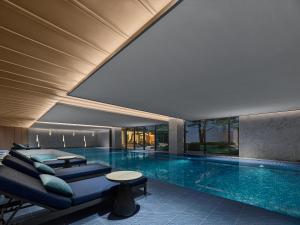 a swimming pool with a couch and a table in a building at Angsana Suzhou Shishan in Suzhou