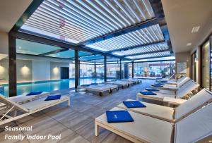 a swimming pool with many beds in a building at Luna Holiday Complex in Mellieħa