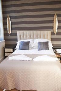 una camera da letto con un letto grande con due cuscini di The Coral Suite a Southport