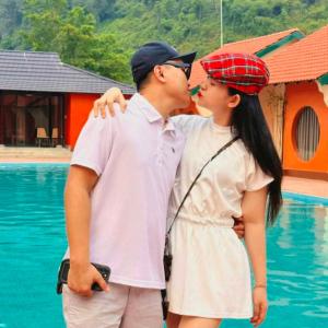 a man and a woman kissing next to a pool at Phong Nha Eco Village in Phong Nha