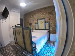 包內伊的住宿－Dommu de Nannai Moro: Camera con bagno e balcone，一间卧室设有一张床和石墙