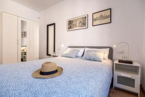 a bedroom with a bed with a hat on it at Tarragona Apartments in Tarragona