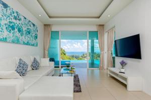 Amala Grand Bleu Resort Hilltops - SHA في شاطئ كامالا: غرفة معيشة مع أريكة بيضاء وتلفزيون