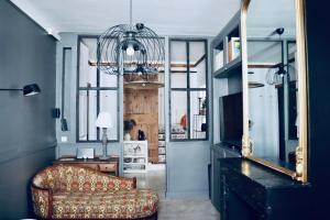 een woonkamer met een bank en een spiegel bij Casa Cabanel in Montpellier