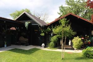 uma casa com um quintal com uma pequena árvore em Frenk cottage 5 KM FROM THE AIRPORT-free transportation em Šenčur