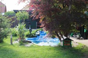a small waterfall in a yard with a tree at Frenk cottage 5 KM FROM THE AIRPORT-free transportation in Šenčur