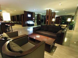 a living room with couches and a table in a building at Mitra Bandung Hotel in Bandung