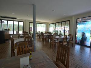 The Green Hotel في كو ليبي: مطعم به طاولات وكراسي وحوض سمك كبير