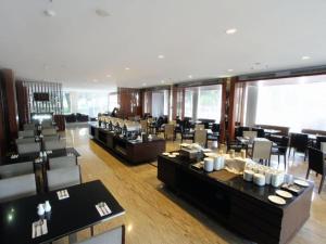a restaurant with tables and chairs in a room at Mitra Bandung Hotel in Bandung