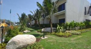 un patio de un edificio con palmeras y una casa en The Green Hotel en Ko Lipe