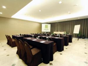 a conference room with black tables and chairs and a screen at Mitra Bandung Hotel in Bandung +83 photos