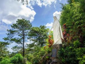 a statue of an angel standing in a garden at V Hotel and Apartel in Baguio