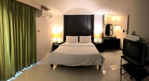 a bedroom with a bed and a flat screen tv at S.C. Heritage Hotel in Hat Yai