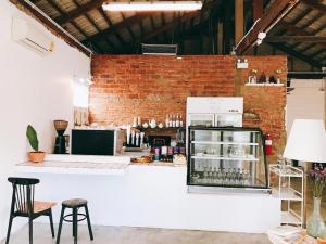 een kamer met een toonbank, stoelen en een bakstenen muur bij Khemjit cafe' and bed in Ban Kao +43 foto's