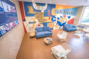a waiting room with blue chairs and a mural at Siri Regent in Ban Noi Pho Kham