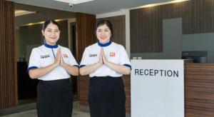 two women standing in a room with their hands at B2 Korat Premier Hotel in Ban Liap