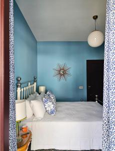 a bedroom with a bed with a blue wall at Villa Gra in Praiano