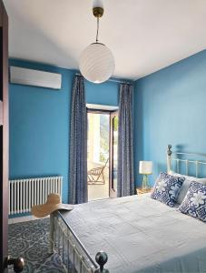 a bedroom with blue walls and a bed at Villa Gra in Praiano