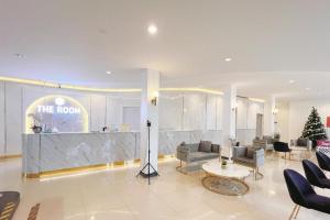 een lobby met banken en een balie in een gebouw bij The Room Hotel in Ban Nong Puk
