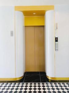 een hal met een deur in een gebouw met een geruite vloer bij The Room Hotel in Ban Nong Puk