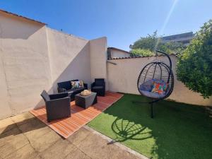 une cour avec une chaise et une balançoire dans l'établissement Le Patio - Maison avec Jardin - WIFI, à Bègles