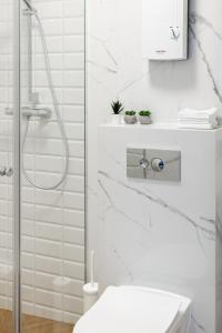 bagno bianco con doccia e servizi igienici di „MAZURSKIE PTAKI” Domki Letniskowe a Ruciane-Nida