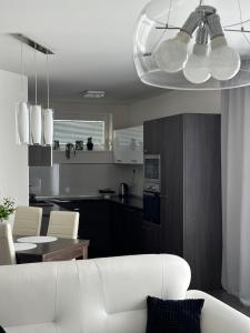 a living room with a white couch and a kitchen at Panorama Apartments Presov in Prešov