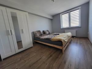 une chambre avec un lit et une grande fenêtre dans l'établissement ApartHotel9, à Bystrzyca Kłodzka