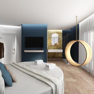 a bedroom with a large bed and a mirror at Ambasciatori Suite Hotel in Sottomarina