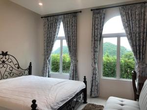 a bedroom with a bed and two large windows at KHAO YAI MY WAY in Ban Tha Chang +37 photos