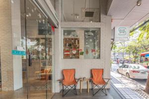 曼谷的住宿－Simply Sleep Hostel，两个橙色椅子坐在商店外面