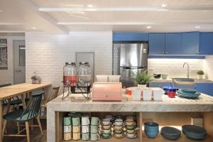 uma cozinha com armários azuis e um balcão com pratos em Simply Sleep Hostel em Banguecoque